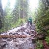 Weg, der mit Wasser gefüllt ist und ein Biker, der sein Velo stösst